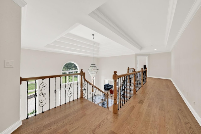 hall featuring an upstairs landing, wood finished floors, crown molding, and baseboards