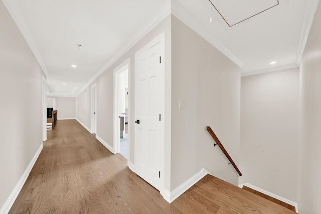 hallway featuring an upstairs landing, attic access, crown molding, light wood-style floors, and recessed lighting