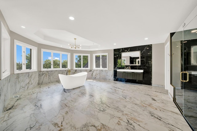 living room with a chandelier, a tray ceiling, light marble finish flooring, and recessed lighting