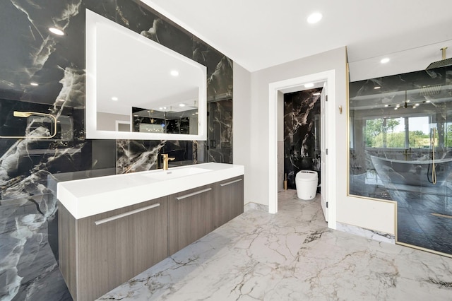 full bathroom with marble tiled floors, vanity, recessed lighting, and stone wall