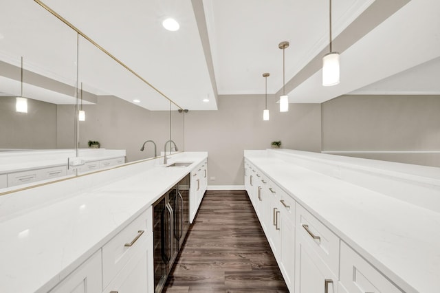 kitchen with dark wood-style flooring, a sink, light stone counters, hanging light fixtures, and recessed lighting