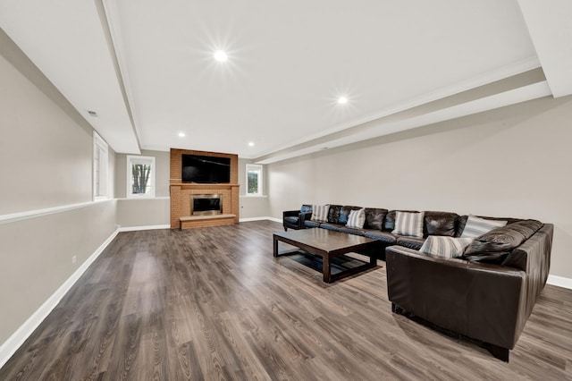 living area with a brick fireplace, baseboards, recessed lighting, and dark wood-style floors
