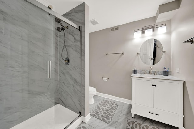 bathroom with marble finish flooring, baseboards, a shower stall, toilet, and vanity