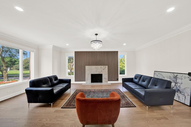 living room featuring baseboards, crown molding, light wood-style floors, recessed lighting, and a chandelier