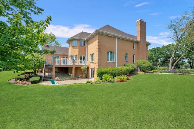 back of property with stairs, a deck, a chimney, and a lawn