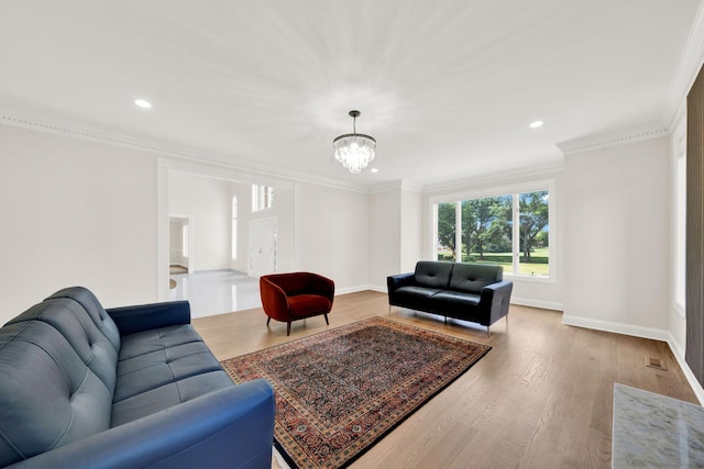 living area featuring a chandelier, wood finished floors, recessed lighting, baseboards, and ornamental molding