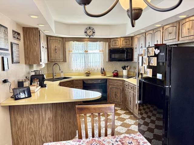 5600 Saint Charles Rd, Berkeley, IL 60163 - kitchen with black appliances, a sink, a peninsula, backsplash, and light countertops