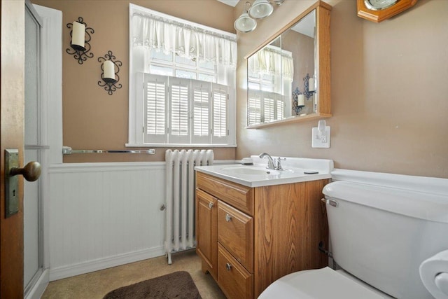 bathroom with radiator, a wainscoted wall, toilet, and vanity