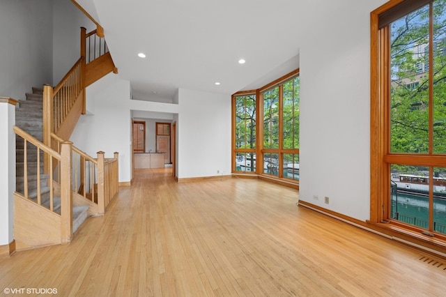 456 E N Water St Unit H, Chicago, IL 60611 - unfurnished living room with light wood-style floors, healthy amount of natural light, stairway, recessed lighting, and baseboards