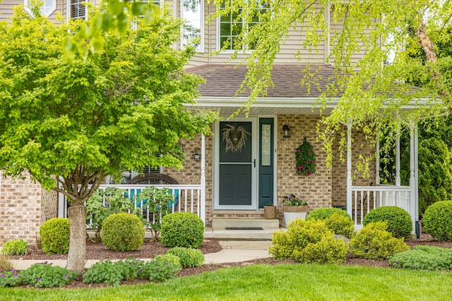 25037 W Liberty Dr, Channahon, IL 60410 - view of front of house with brick siding, a porch, and a shingled roof
