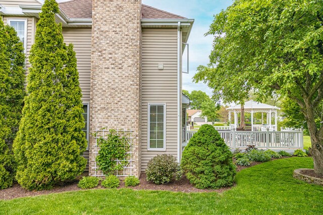 25037 W Liberty Dr, Channahon, IL 60410 - view of home's exterior with a gazebo, a chimney, a yard, and roof with shingles