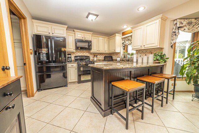 25037 W Liberty Dr, Channahon, IL 60410 - kitchen featuring black appliances, cream cabinetry, light tile patterned flooring, tasteful backsplash, and a peninsula