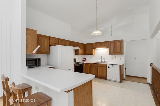 6109 Golfview Dr Unit 6109, Gurnee, IL 60031 - kitchen featuring white appliances, light countertops, light flooring, a peninsula, and brown cabinetry