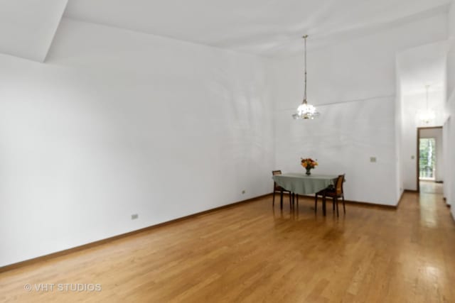 6109 Golfview Dr Unit 6109, Gurnee, IL 60031 - empty room featuring light wood finished floors, a chandelier, and a high ceiling