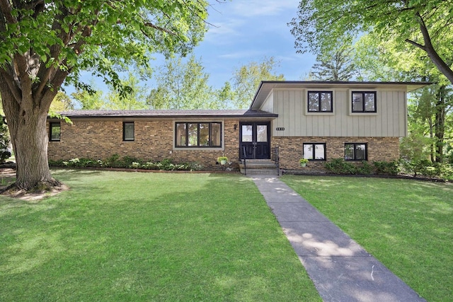 tri-level home with brick siding and a front lawn
