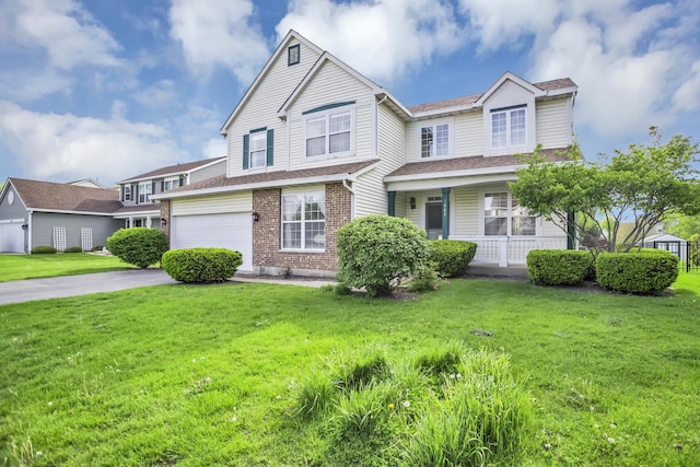 view of front of property featuring a front lawn, concrete driveway, and covered porch