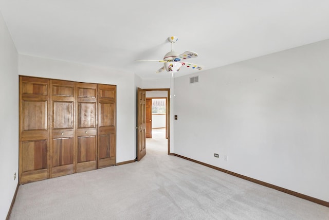 unfurnished bedroom with light carpet, baseboards, and a ceiling fan