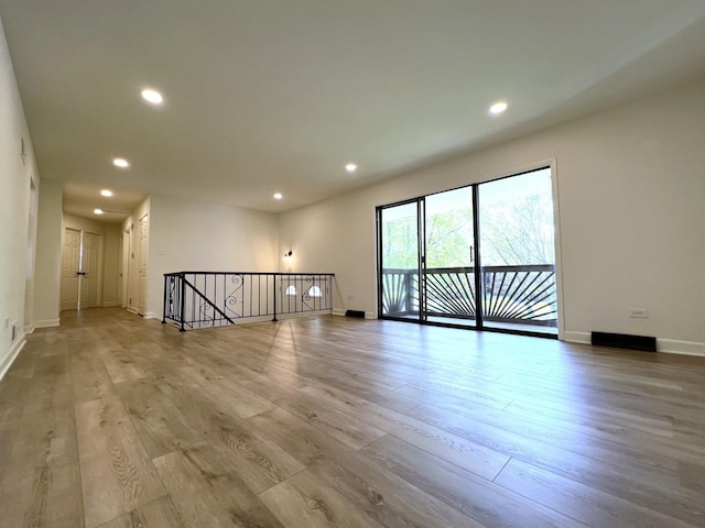 empty room with wood finished floors, recessed lighting, and baseboards