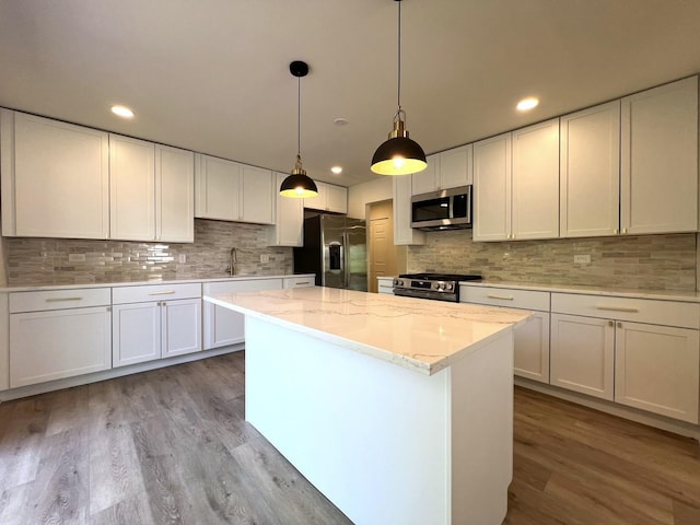 kitchen with stainless steel appliances, wood finished floors, decorative backsplash, and recessed lighting