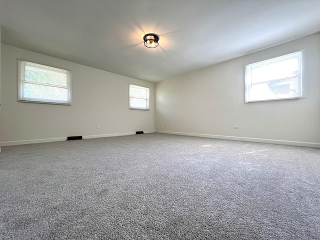 unfurnished room with baseboards and carpet