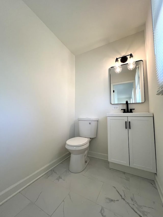 bathroom featuring marble finish flooring, baseboards, toilet, and vanity