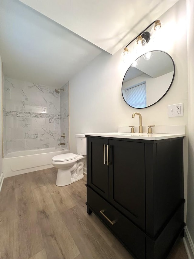 bathroom with wood finished floors, toilet, shower / washtub combination, and vanity