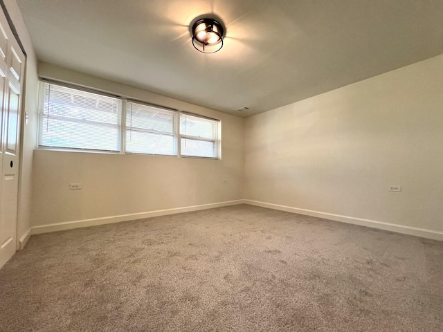 unfurnished room featuring carpet flooring and baseboards