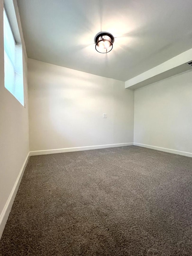 spare room featuring carpet flooring and baseboards