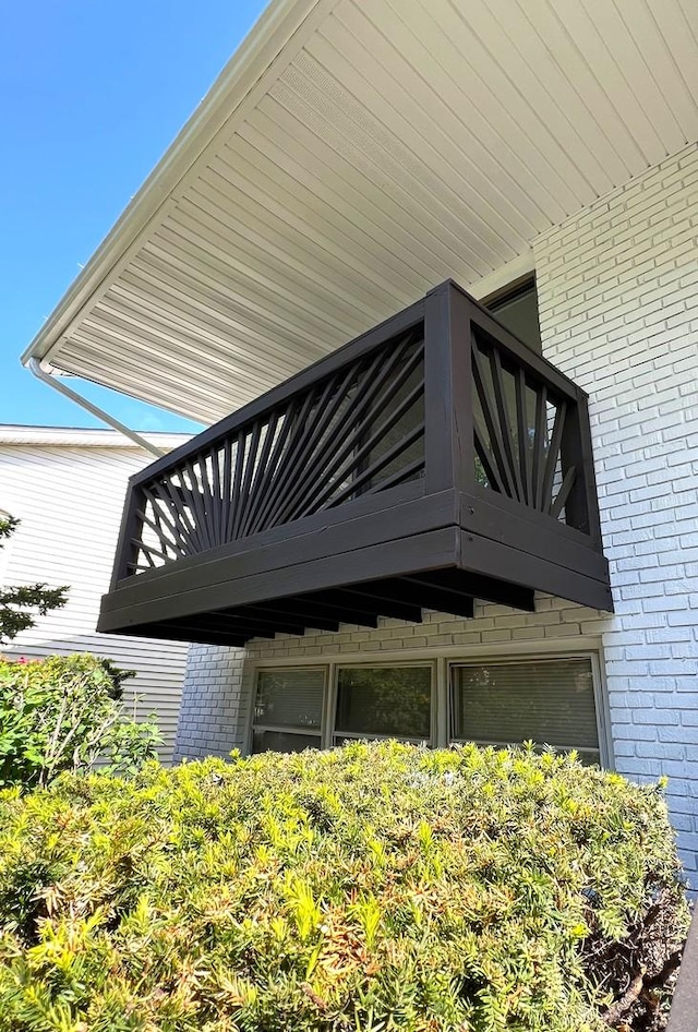 view of property exterior featuring a balcony and brick siding
