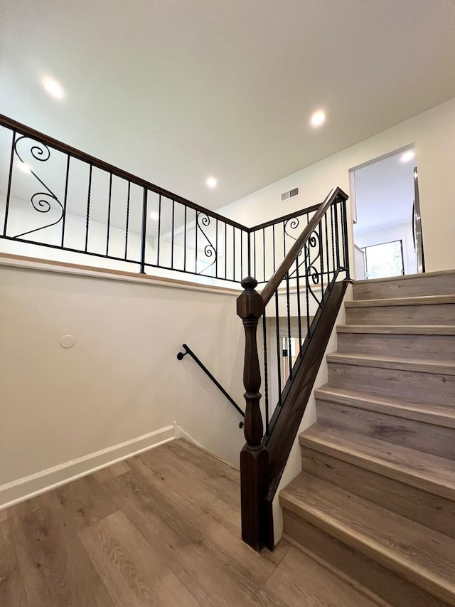 stairs featuring wood finished floors and baseboards