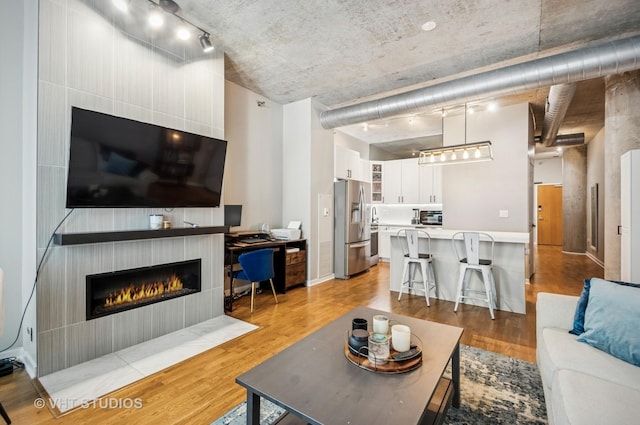 700 N Larrabee St Unit 905, Chicago, IL 60654 - living room featuring a fireplace, light wood-style floors, and rail lighting
