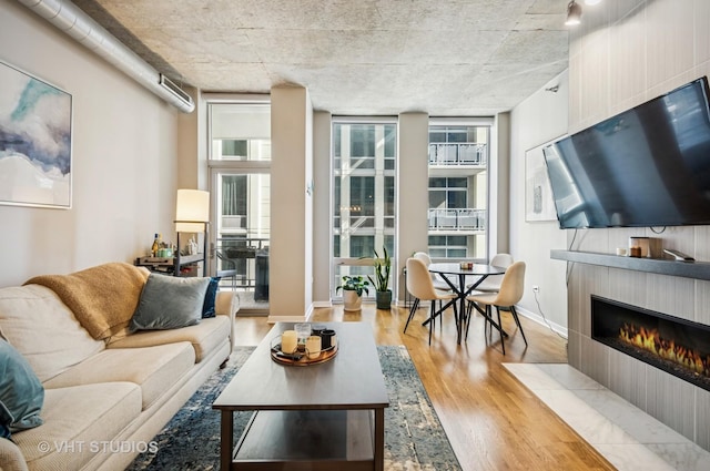 700 N Larrabee St Unit 905, Chicago, IL 60654 - living area with wood finished floors, a tile fireplace, expansive windows, and baseboards