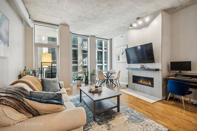 700 N Larrabee St Unit 905, Chicago, IL 60654 - living room with wood finished floors, a large fireplace, rail lighting, and baseboards