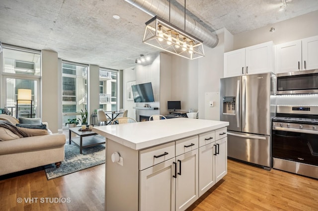 700 N Larrabee St Unit 905, Chicago, IL 60654 - kitchen with appliances with stainless steel finishes, open floor plan, light wood-type flooring, white cabinets, and a kitchen island