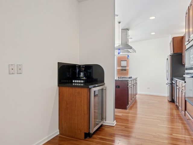 501 N Kingsbury St Unit G, Chicago, IL 60654 - kitchen with extractor fan, beverage cooler, light wood-style floors, dark countertops, and brown cabinetry