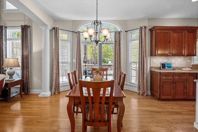 1021 Fire Fox Ct, Saint Charles, IL 60174 - dining space featuring light wood-type flooring, a chandelier, baseboards, and ornate columns