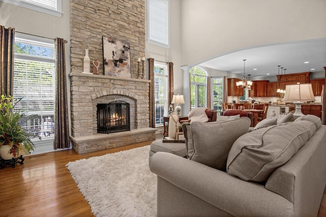 1021 Fire Fox Ct, Saint Charles, IL 60174 - living area featuring a chandelier, wood finished floors, a stone fireplace, a towering ceiling, and recessed lighting