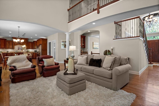 1021 Fire Fox Ct, Saint Charles, IL 60174 - living area featuring a chandelier, arched walkways, wood finished floors, baseboards, and a high ceiling