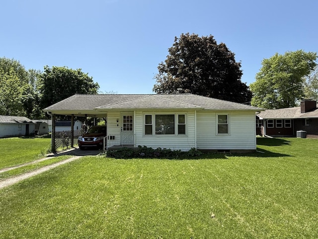 view of front of house featuring driveway, a front yard, an attached carport, and central AC unit