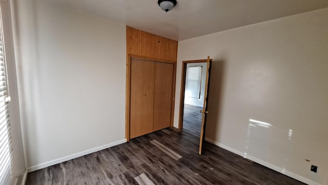 443 E St, Depue, IL 61322 - unfurnished bedroom with a closet, dark wood finished floors, and baseboards