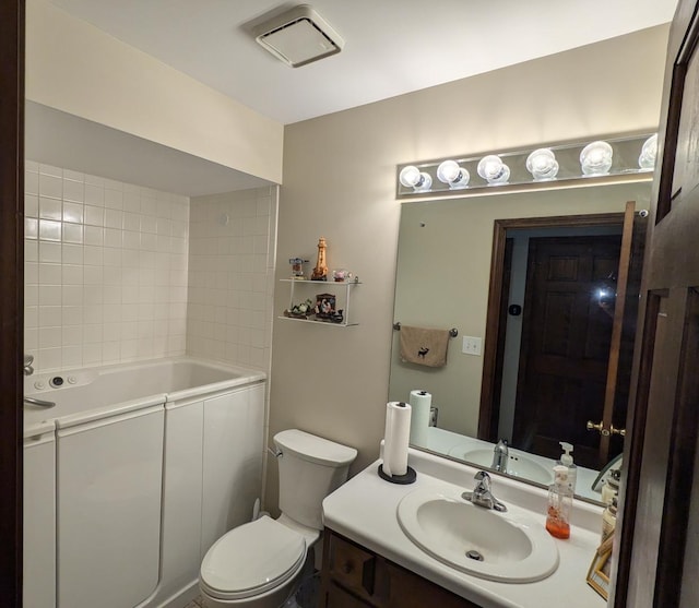 bathroom featuring toilet, a tub, and vanity