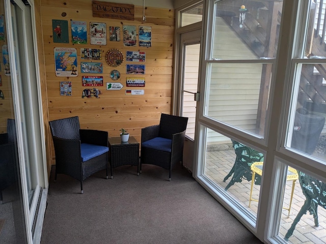 living area with wood walls and carpet flooring