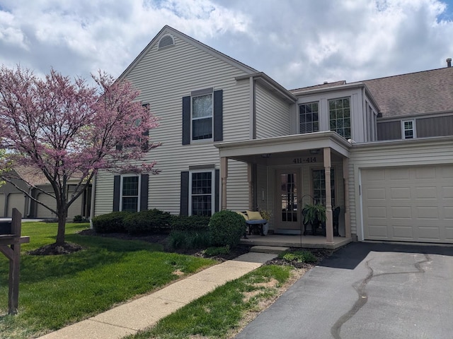 view of front of property featuring a porch, a front yard, and asphalt driveway