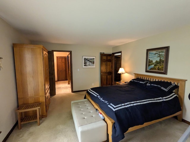 bedroom with light colored carpet and baseboards