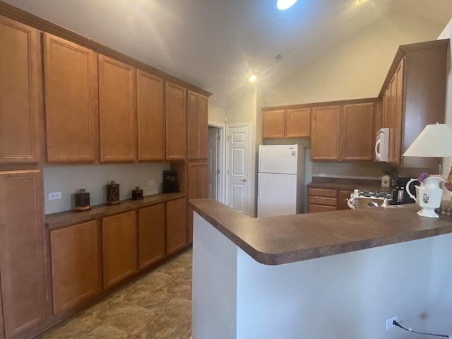 2018 Olmstead Dr Unit 2018, Woodstock, IL 60098 - kitchen featuring white appliances, dark countertops, a peninsula, and lofted ceiling