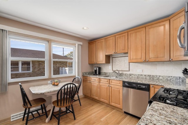 4522 N Reserve Ave, Chicago, IL 60656 - kitchen with dishwasher, a sink, light wood-style floors, tasteful backsplash, and light stone countertops