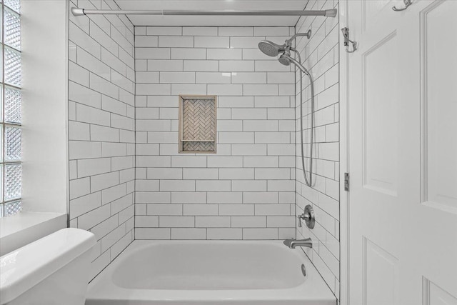 full bath featuring plenty of natural light, washtub / shower combination, and toilet