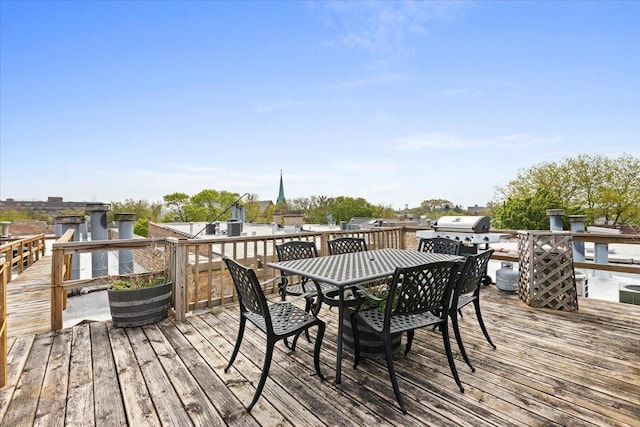 wooden terrace featuring outdoor dining space and area for grilling
