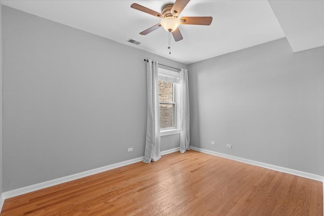 spare room featuring baseboards, light wood-style flooring, and ceiling fan