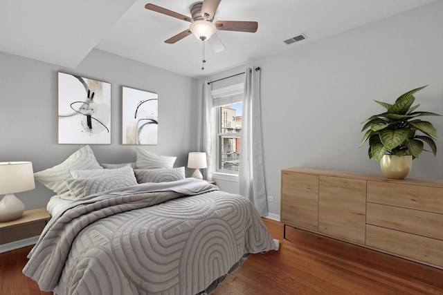 bedroom with wood finished floors, baseboards, and a ceiling fan